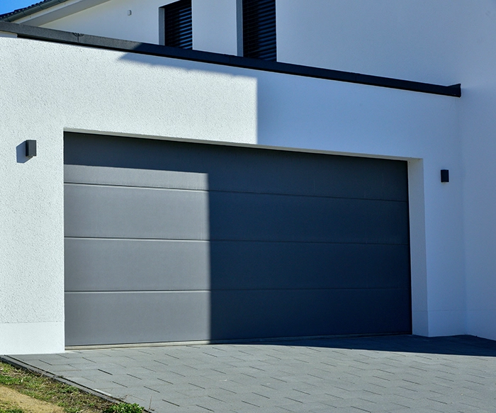 Porte de garage sectionnelle moderne installée sur une maison individuelle au Luxembourg