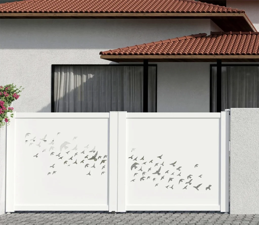 Portail battant blanc avec motif décoratif oiseaux installé devant une maison